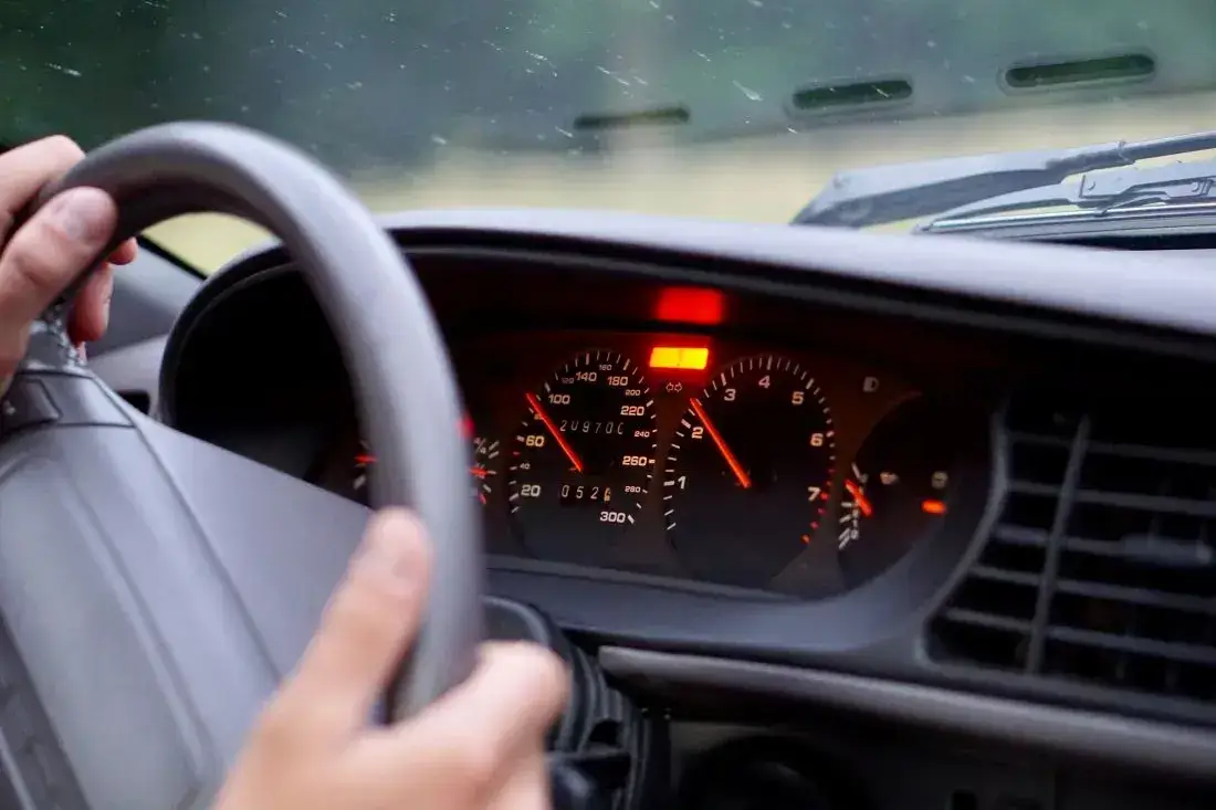 Die Grafik zeigt eine rot blinkende Kontrollleuchte im Auto als Zeichen, bald eine Reparatur durchführen lassen.