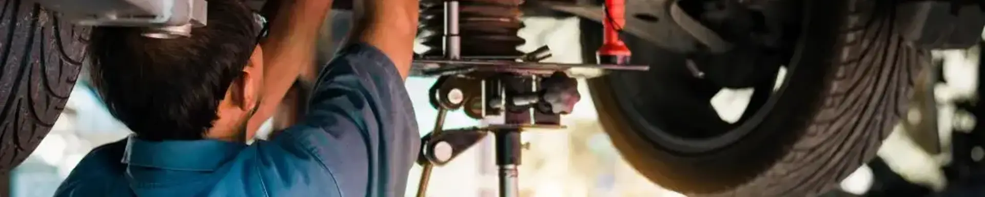 Wann muss ich meine Stoßdämpfer wechseln? Ein Kfz-Mechaniker nimmt einen Wechsel der Stoßdämpfer am Auto vor.