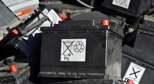 Autobatterien entsorgen: Wo kommen alte, defekte und leere Batterien hin? Ein Schild auf einer alten Autobatterie klärt über das richtige Entsorgen auf.
