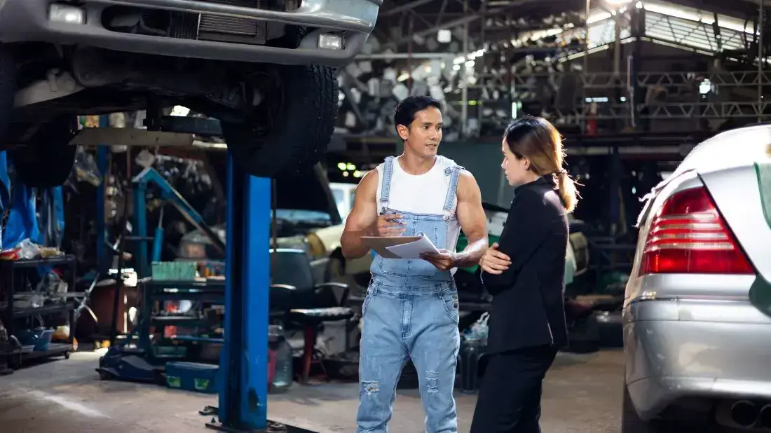 Die Grafik zeigt eine Kundin in einer Werkstatt, um die Bremsscheiben ihres Autos zu wechseln.