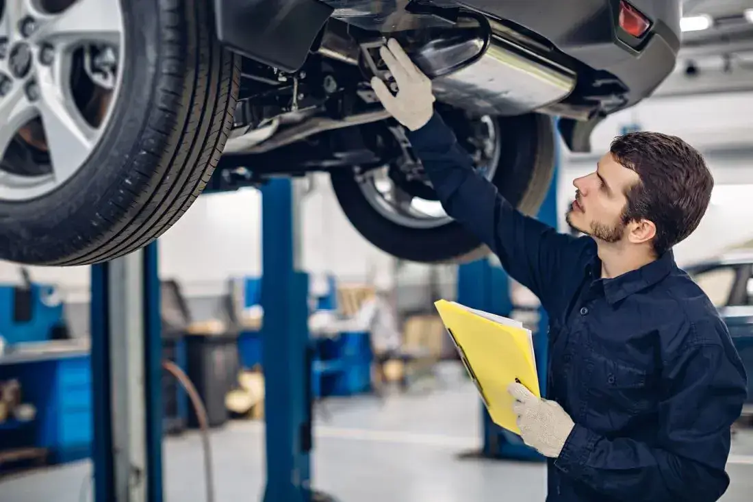 Ein Kfz-Mechaniker führt in einer Werkstatt eine Inspektion durch, damit der Besitzer langfristig Kosten sparen kann.