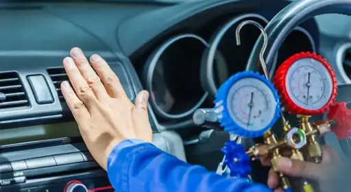 Die Klimaanlage im Auto kühlt nicht: Was können die Ursachen sein? Ein Autofahrer prüft, ob die Klimaanlage im Auto defekt ist.