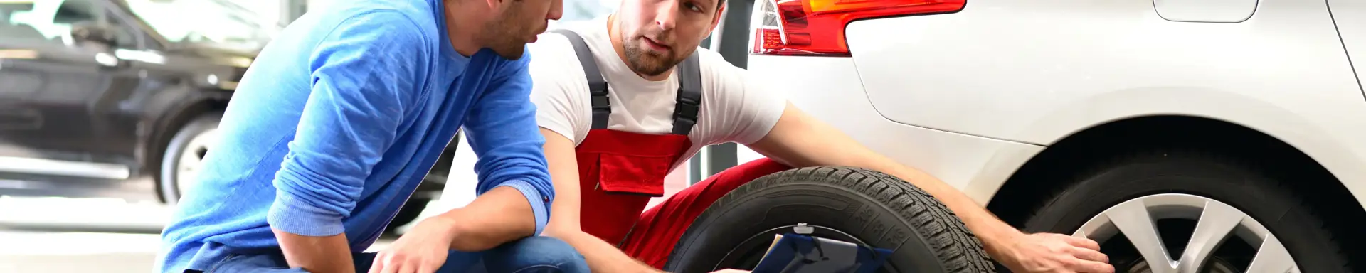 Was heißt Mischbereifung? Ein Mechaniker berät einen Mann zu einer möglichen Mischbereifung für seinen Pkw.