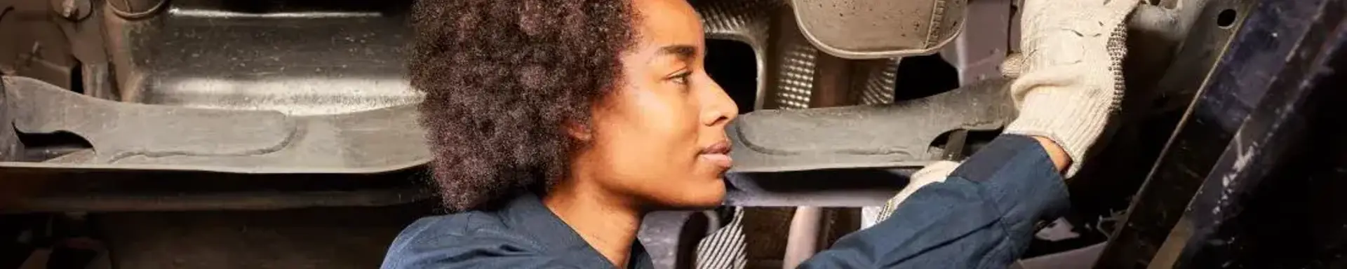 Defekte Stoßdämpfer: Symptome erkennen Eine Kfz-Mechanikerin prüft einen möglichen defekten Stoßdämpfer am Auto.